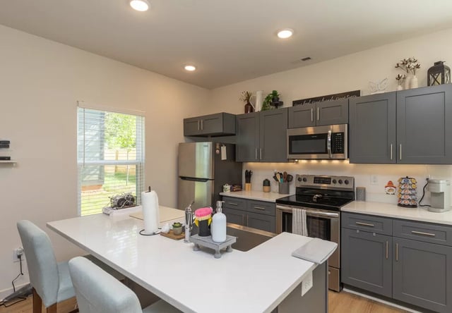 Modern grey cabinets stainless steel appliances kitchen island kitchen at Varsity Club in Clemson Student Accommodation